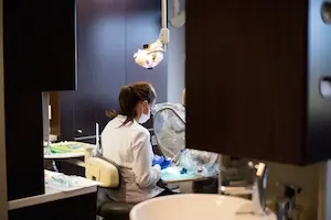Dentist performing treatment on patient in modern dental operatory at VisitYourDentist-Dentistry@10.